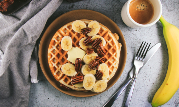 Greek Yogurt Waffles with Bananas, Candied Pecans, Maple Rum Syrup and Whipped Cream