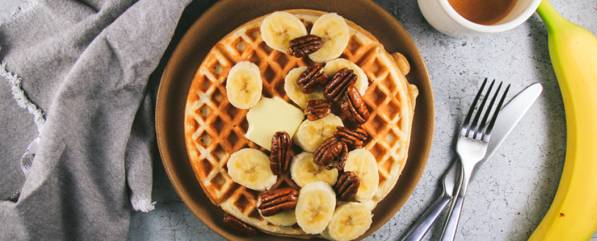 Greek Yogurt Waffles with Bananas, Candied Pecans, Maple Rum Syrup and Whipped Cream